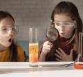 two girls wearing goggles doing science