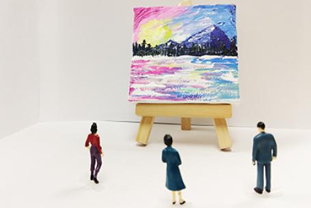 tiny painting on wooden easel being viewed by small human figures